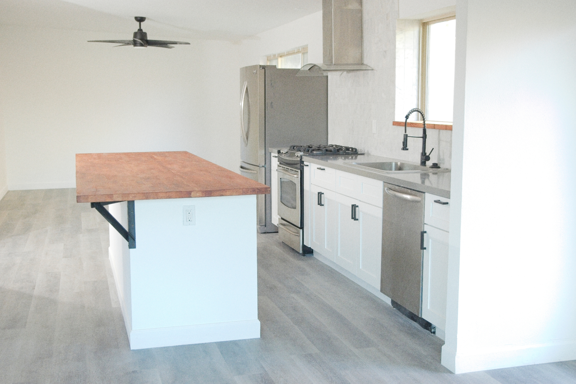 Kitchen remodel with butcher block island and stainless steel appliances